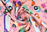 Swirled swatch Cat Race fabric (pale coral pink with busy tossed doodle style cats in cars, tossed flowers and birds all in bright colours)