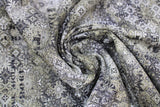 Swirled swatch faded tile fabric (busy decorative tile motif allover in white, black, grey collaged with faint black lettering)