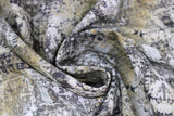Swirled swatch Du Theater fabric (neutral toned fabric with subtle circular decorative coins/medallions in white and black with grey and yellow rust coloured areas and subtle black text)
