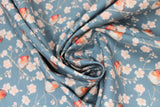 Swirled swatch Linotte fabric (pale blue/grey fabric with grey branches and white/pink cherry blossom look flowers allover with little birds sitting on branches in white, grey with orange faces/bellies)