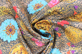 Swirled swatch gaia fabric (small cheetah print background in beige, tan with black spots and tossed floral heads in pink, red and blue, circular gold lion brooches, gold floral appliques with red and purple tassels)