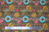 Flat swatch gaia fabric (small cheetah print background in beige, tan with black spots and tossed floral heads in pink, red and blue, circular gold lion brooches, gold floral appliques with red and purple tassels)