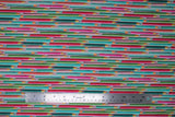Flat swatch pencils fabric (purple/grey fabric with lines of coloured pencils in blue, green, red, pink tones looking as though they are shooting across the fabric)
