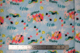 Flat swatch (side 1) Arielle fabric (light blue fabric with tossed cartoon style mermaids with coral hair and teal tails, gold crowns and accessories, tossed greenery in green and white, tossed fish and sea creatures)