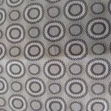 Square swatch upholstery fabric with circles (within circles) print in silver/black/grey shades