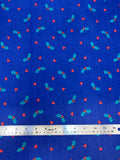 Flat swatch winter themed flannel in Mistletoe on blue (tiny hollies on medium blue)