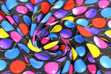 Swirled swatch Balloons fabric (black fabric with coloured balloons allover in blue, purple, pink, red, yellow with multicoloured strings)