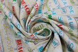 Swirled swatch Beach Signs fabric (white/beige speckled sand look fabric with busy white board look signs allover in various sizes and shapes with beach related text in various colours allover "Beach" "Sea Side" "Life Guard" etc.)