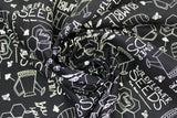 Swirled swatch Bee Yourself fabric (black fabric with busy tossed white writing allover with bee related graphics and doodles: honey combs, watering cans, etc. and bee related text "Wildflower Seeds" etc)