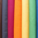 Vertical stack of fabric bolts with Broadcloth Solids in various colours