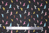 Flat swatch assorted black fabric (black fabric with tossed small assorted cartoon dogs and tiny bones in yellow, blue, pink colourway with brown weiner dogs)