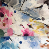 Fanned swatches of smooth, tightly woven white upholstery fabric with printed watercolour floral patterns.  The top colourway features navy and dark brown shades, the middle has pinks, yellows and light blues with green leaves, and the bottom features mid blues and mid browns.