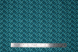 Flat swatch Flower Chain fabric (dark blue fabric with floral geometric style design allover: small leaves in various teal shades arranged to make a 4 point flower with a small green square center)