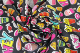 Swirled swatch food toss fabric (cartoon/illustrative style food badges in full colour with white borders tossed allover black fabric: fries, cola, donuts, bananas, hamburgers, pizza, fruit, etc.)
