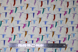 Flat swatch Green Flags fabric (white fabric with loosely spaced blue post drawn flags with various coloured sails/flags: blue, green, pink, red, purple, etc. with words such as "Love" "Bravery" "Compassion" etc on them)