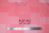 Flat swatch someday fabric (bubblegum pink fabric comprised of square and rectangle labels/patches with different styles, some floral, stripes with white, chevron, triangles, etc.)