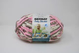 Ball of Bernat Baby Blanket in shade Little Petunias (taupe, pink, white)