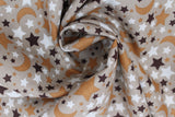 Swirled swatch small stars and moons printed fabric in black (tan/beige fabric with tossed stars and moons allover in white, black, brown)