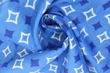 Swirled swatch of blue fabric in diamonds (medium blue fabric with dark blue solid diamond star shapes and white outline diamond star shapes tiled)