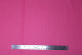 Flat swatch of assorted moderns printed fabric in dots (bubble gum pink fabric with tiny white polka dots)