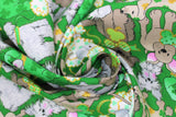 Swirled swatch Lucky Puppies fabric (green fabric with busy collaged cartoon/drawn style dogs in various breeds with clover accents: in mouths or on fur, etc.)