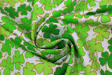 Swirled swatch Clover Stripe fabric (white fabric with lines/stripes of clover leaves outlined in gold sparkles all in various shades of green)