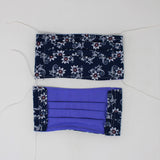 Front and back view of mask with white elastic ear loops (navy blue mask with white paisley look floral allover with burgundy floral center details)