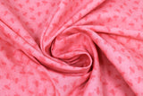 Swirled swatch Orange Bees fabric (pale orange fabric with dark orange bee silhouettes allover)