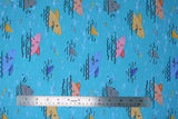 Flat swatch sharks fabric (light blue fabric with smiling cartoon/drawing style shark heads sticking out of water in orange, pink, blue, grey, some shark fins sticking out only, black wave lines)