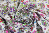 Swirled swatch small white sugar skulls fabric (white fabric with small tossed white and multi-coloured sugar skulls allover with tossed colourful floral)