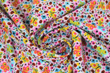 Swirled swatch Spring Floral fabric (white fabric with busy tossed simple style floral and butterflies and lady bugs collaged all together in yellow, orange, pink, red, blue, green, etc. shades)