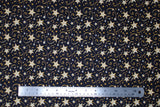 Flat swatch shooting gold fabric (black fabric with small and medium sized white and yellow/gold stars with swoopy shooting star like designs behind)