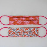 Front and back view of mask with pink elastic ear loops (orange mask with faint pink tie die floral look design)
