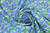 Swirled swatch Wildflower Field fabric (natural fabric with busy tossed drawn style floral heads and green leaves in blue and purple with green)