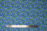 Flat swatch Wildflower Field fabric (natural fabric with busy tossed drawn style floral heads and green leaves in blue and purple with green)