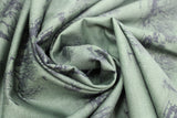 Swirled swatch yuletide themed printed fabric in Dashing Through The Snow (green outdoor scene)