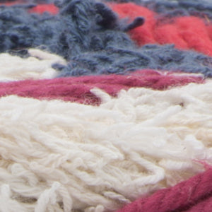 Ball of Scrub Off yarn in shade beach house (white, coral, berry, denim colourway)