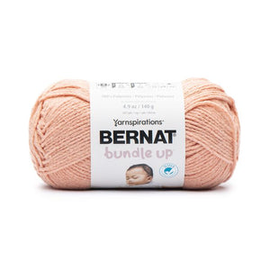 A ball of Bernat Bundle Up yarn in shade Apricot (pale orange)