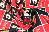 Swirled swatch licensed NHL fabric in Calgary Flames (quilt squares pattern with red and black backgrounds with logo, red background with team text)