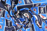 Swirled swatch licensed NHL fabric in Winnipeg Jets (quilt squares pattern with blue and navy backgrounds with logo, navy background with team text, blue background with crossing sticks)