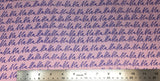 Flat swatch cursive writing bla bla bla fabric in pink (pink fabric with purple "bla bla bla" cursive writing allover in neat lines)
