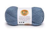 A ball of Lion Brand Touch of Alpaca yarn in dusty blue shade on white background (pale medium blue)
