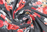 Swirled swatch black/red roses jersey knit fabric (charcoal fabric with white flower silhouettes and red colourway flower clusters)