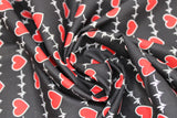 Swirled swatch hearts and heartbeat lines printed fabric on black (red hearts and white lines on black)