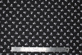 Flat swatch skull printed fabric in small white skull and crossbones on black