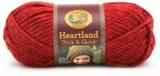 A ball of Lion Brand Heartland Thick & Quick in colourway Redwood (heathered bright red)