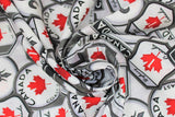 Swirled swatch Canadian signs grey fabric (white fabric with tossed collaged Canadian badges and signs in white, black, grey with red accents "Canada", flags, Highway 1, etc.)