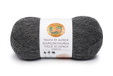 A ball of Lion Brand Touch of Alpaca yarn in charcoal grey shade on white background