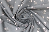 Swirled swatch skulls fabric in grey (medium grey fabric with white small skull and crossbones tossed allover)