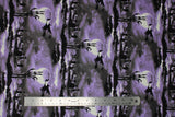 Flat swatch Creatures of the Night fabric (purple and grey misty look sky fabric with black silhouette graphic of graveyard with hand sticking out of ground and witch flying over)